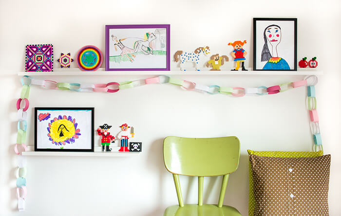 Stylowe białe półki na obrazy dekorowane kolorowymi obrazkami dla dzieci i innymi pięknymi przedmiotami Biała listwa na obrazy w pokoju dziecięcym